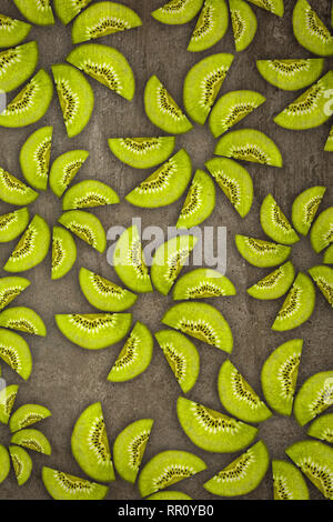 Creative flowers made of Kiwis cut from below lit on a stone background Food concept Stock Photo