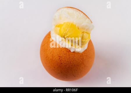 Cracked exploded egg with yoke showing isolated on a white background Stock Photo