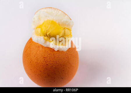 Cracked exploded egg with yoke showing isolated on a white background Stock Photo