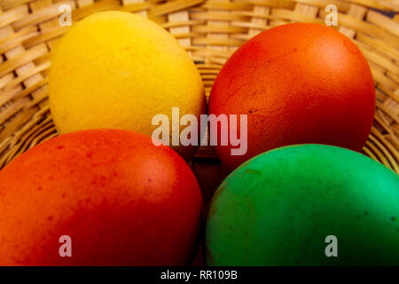 Four colorful easter eggs in basket isolated Stock Photo