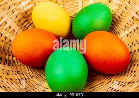 Five colorful easter eggs in a straw basket isolated Stock Photo