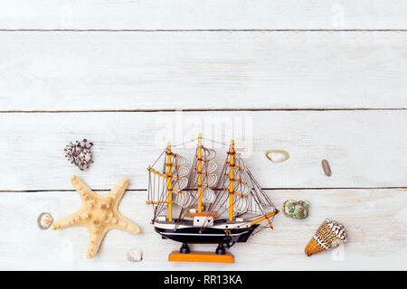Ship and seashells on wooden background. Copy space Stock Photo