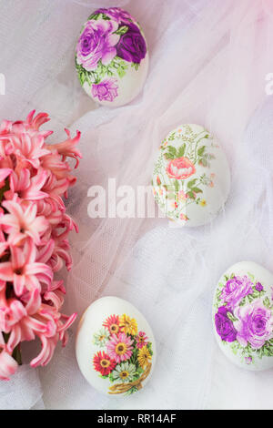 Beautiful Easter eggs decorated with paper napkins and flowers on white tulle background; decoupage technique Stock Photo