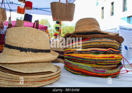 Colorful straw hats and bags at a Market for sale Stock Photo