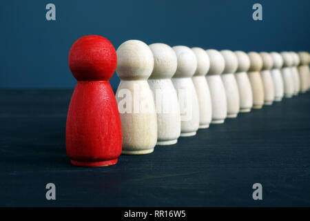 Hierarchy management and leadership concept. Being and the first. Red figurine ahead. Stock Photo