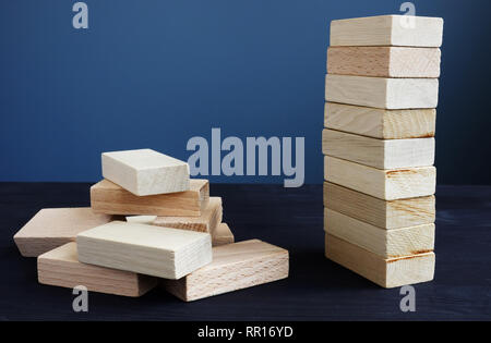 Organization, strategy and risk in business concept. Tower and piled up from wooden bricks. Stock Photo