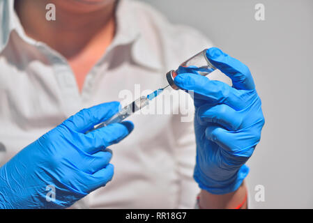 Closeup of vaccine bottle with syringe and needle for immunization on vintage medical background, medicine and drug concept Stock Photo