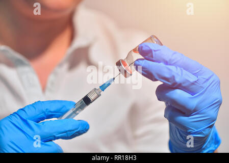 Closeup of vaccine bottle with syringe and needle for immunization on vintage medical background, medicine and drug concept Stock Photo