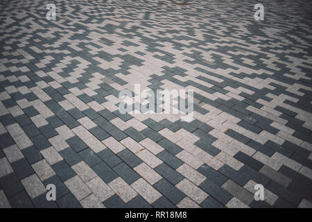 Gray and white patterned paving tiles on the ground of street, perspective view. Cement brick squared stone floor background. Concrete paving slab fla Stock Photo