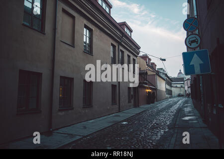 Ancient narrow Vilnius street with old architecture and winter background Stock Photo