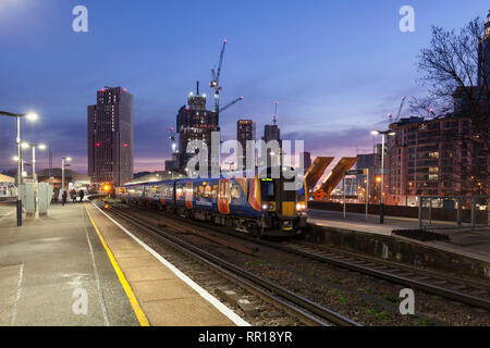 2 South Western railway class 450 EMU's call at  Vauxhall station, Londonwith the London Skyline behind at dusk Stock Photo