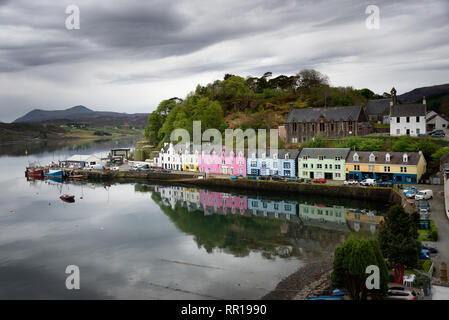 Colorful rainbow houses with reflection in the water of the harbor of Portree on an overcast day on the Isle of Skye, Inner Hebrides in Scotland, UK. Stock Photo