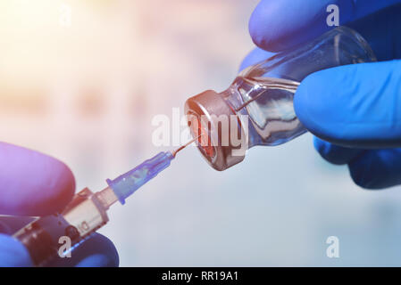 Closeup of vaccine bottle with syringe and needle for immunization on vintage medical background, medicine and drug concept Stock Photo