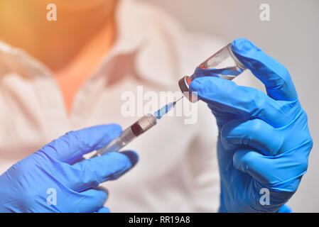 Closeup of vaccine bottle with syringe and needle for immunization on vintage medical background, medicine and drug concept Stock Photo