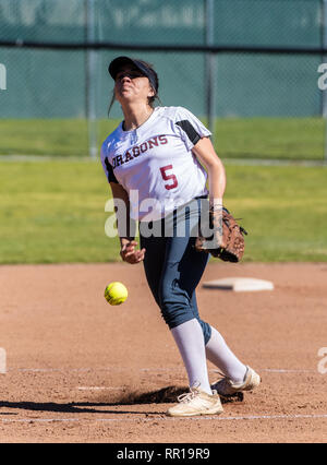 Softball player in white uniform releasing a pitch during right hand delivery in game between Foothill Technology High School and Pioneer Valley on Fe Stock Photo