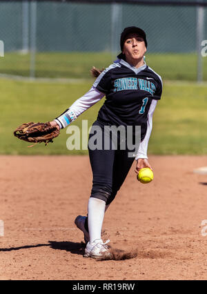 Softball player in black uniform releasing a pitch during left hand delivery in game between Foothill Technology High School and Pioneer Valley on Feb Stock Photo