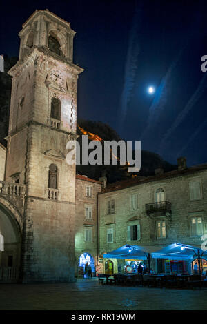 St Tryphon's Cathedral (Katedrala Sv Tripuna) in the eponymous square (Trg Sv Tripuna) and the city fortifications illuminated above on a moonlit even Stock Photo