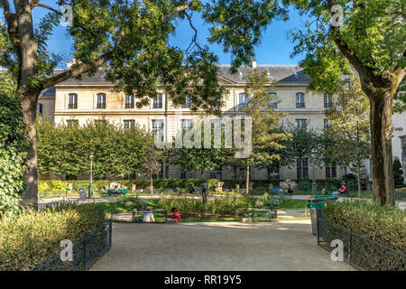 People enjoying the sunshine in Square George Cain, in the fashionable  Le Marais district of Paris Stock Photo