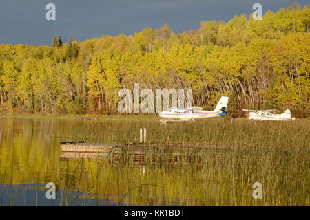 Two float planes docked at a lakeside cottage in the boreal forest town of Missinipe, northern Saskatchewan, Canada. Stock Photo