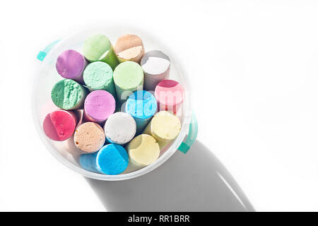 Pack of Jumbo Sidewalk Chalk, Assorted Colors in a Plastic Bucket on White Background with Shadow. Top View. Stock Photo