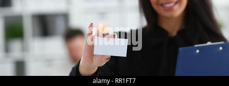 Female arm give blank calling card to visitor Stock Photo