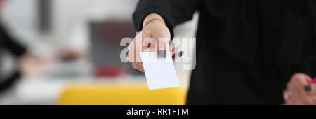 Female arm give blank calling card to visitor Stock Photo