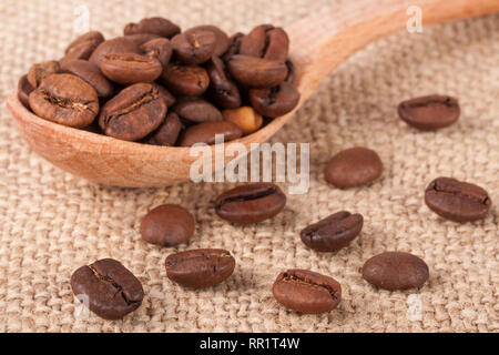 Coffee beans in a wooden spoon on sackcloth Stock Photo