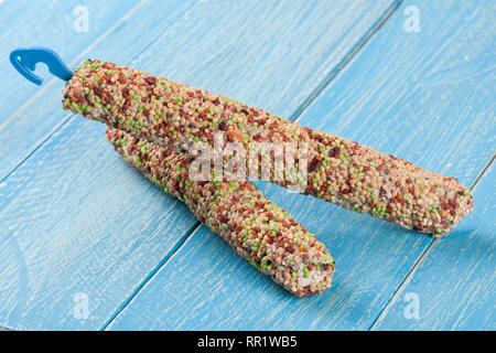 food for parrots on a stick blue wooden background Stock Photo