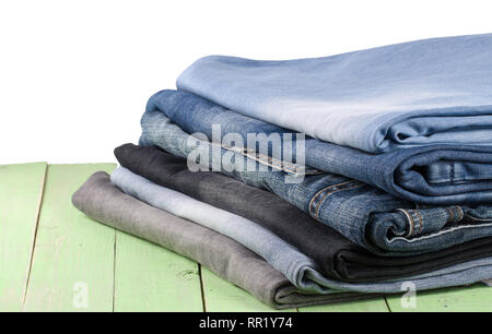 stack of jeans on green wooden background Stock Photo