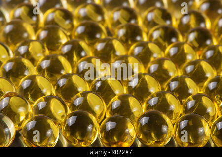 a lot of fish oil capsules on a dark background Stock Photo