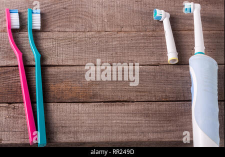 electric and manual toothbrushes on the wooden background Stock Photo