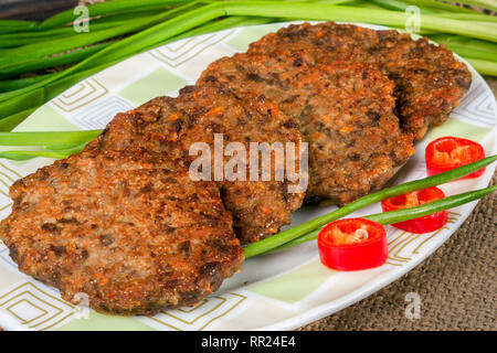 liver pancakes or cutlets with chili pepper and green onions on a wooden background Stock Photo