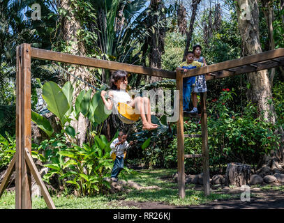 latin siblings playing on playground in Guatemala Stock Photo