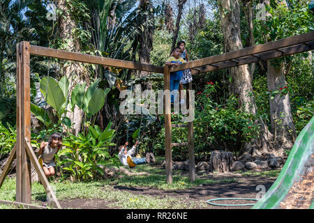 latin siblings playing on playground in Guatemala Stock Photo