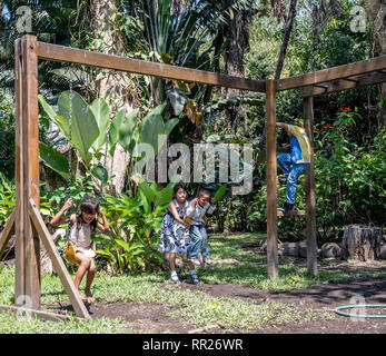 latin siblings playing on playground in Guatemala Stock Photo