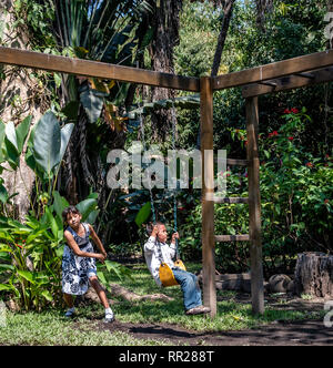 latin siblings playing on playground in Guatemala Stock Photo