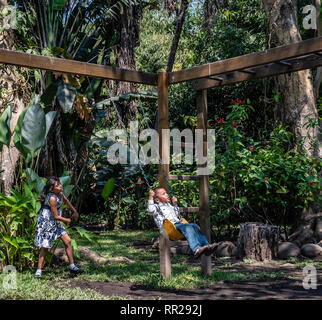 latin siblings playing on playground in Guatemala Stock Photo