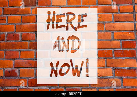 Handwriting text writing Here And Now. Concept meaning Present at this exact moment Compromise Engagement in situation Brick Wall art like Graffiti mo Stock Photo
