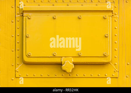 bright yellow painted metal plate texture with hatch and rivets Stock Photo