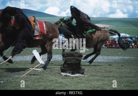 Caption: Litang, Sichuan, China - Aug 2003. Khampa horsemen compete at the shooting event during the Horse Racing Festival in Litang, the former Tibet Stock Photo