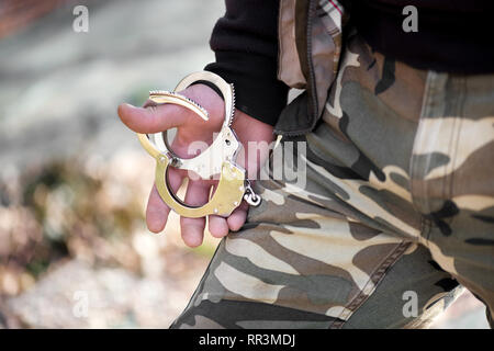Police officer holding handcuffs Stock Photo - Alamy