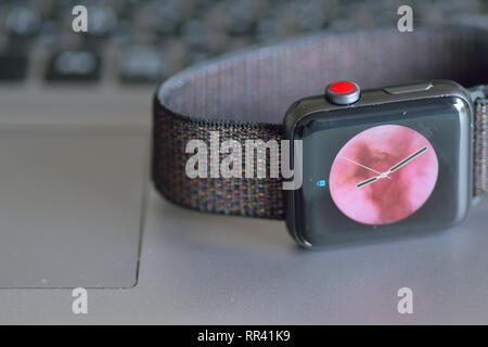 Apple Watch with blurred laptop PC keyboard background. Apple Watch is industry leader smart watch brand Stock Photo