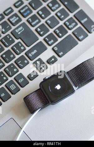 Apple Watch with blurred laptop PC keyboard background. Apple Watch is industry leader smart watch brand Stock Photo