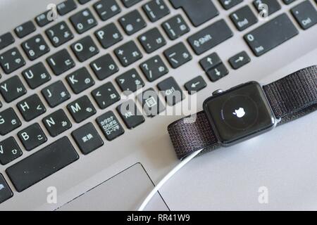 Apple Watch with blurred laptop PC keyboard background. Apple Watch is industry leader smart watch brand Stock Photo