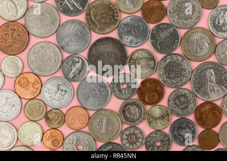 Different country coins on pink background Stock Photo