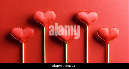 Red textile hearts on wooden sticks closeup. Valentines day background, creative texture and love concept Stock Photo