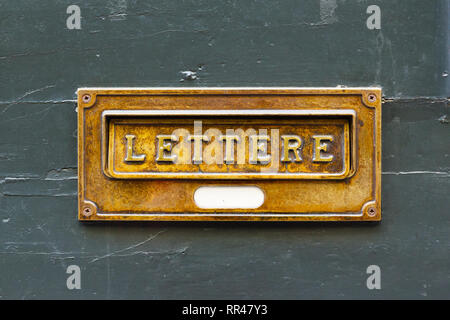 close-up brushed copper letter box on old painted wood Stock Photo