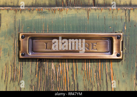 close-up brushed copper letter box on old painted wood Stock Photo