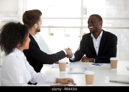 Diverse workers greeting each other in briefing shaking hands Stock Photo