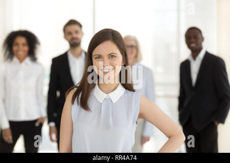 Diverse workers headed by team leader standing together indoors Stock Photo